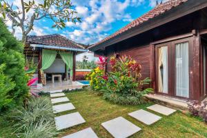 une arrière-cour avec une maison et un jardin dans l'établissement Sri Abi Ratu Villas, à Sukawati