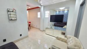 - un salon avec un canapé et une télévision dans l'établissement Espetacular apartamento no centro, à Palmas