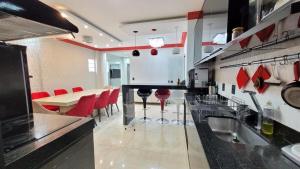 uma grande cozinha com cadeiras vermelhas e uma mesa em Espetacular apartamento no centro em Palmas