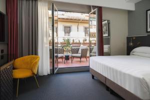 una camera con letto e balcone di iQ Hotel Firenze a Firenze