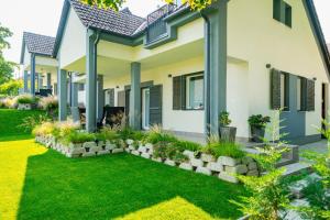 een huis met een tuin ervoor bij Hársliget Apartman in Nagymaros