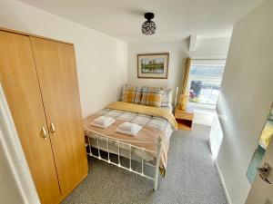 ein kleines Schlafzimmer mit einem Bett und einem Fenster in der Unterkunft Miners cottage(1840)Nr. Brecon,Tower Zip & Bike Pk in Aberdare