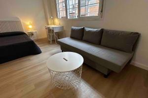 ein Wohnzimmer mit Sofa und Tisch in der Unterkunft Room Pinar - Apartamento con todas las comodidades - VT 14178 in Madrid