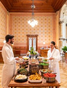 een man en vrouw die voor een buffet staan bij QC room San Pellegrino in San Pellegrino Terme