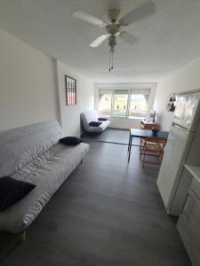 ein Wohnzimmer mit einem Bett und einem Tisch in der Unterkunft LES FLORALIES 2 Studio 4 personnes climatisé, piscine dans la résidence et Parking privé disponible in Le Grau-du-Roi