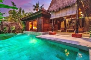 uma villa com piscina em frente a uma casa em Sri Abi Ratu Villas em Sukawati