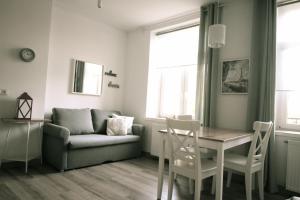 ein Wohnzimmer mit einem Tisch und einem Sofa in der Unterkunft Zamojska Residence Apartments in Lublin
