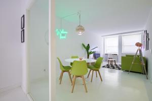 マドリードにあるPlaza España Princesa - Apartamento de 1 dormitorioのテーブルと緑の椅子のあるダイニングルーム