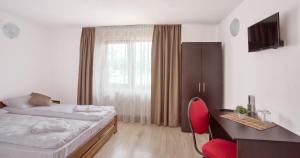 - une chambre avec un lit, un bureau et une chaise rouge dans l'établissement Casa Godi, 