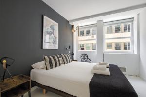 マドリードにあるPlaza España Princesa - Apartamento de 1 dormitorioの白いベッドと2つの窓がある寝室