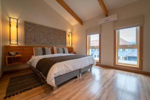 um quarto com uma cama grande e 2 janelas em Hotel casa Solaria em Pucón