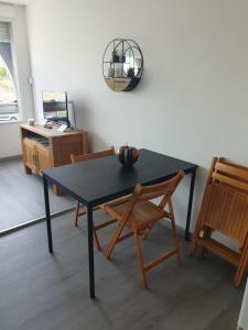 ein Esszimmer mit einem Tisch und zwei Stühlen in der Unterkunft LES FLORALIES 2 Studio 4 personnes climatisé, piscine dans la résidence et Parking privé disponible in Le Grau-du-Roi
