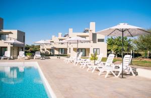 un grupo de sillas y sombrillas junto a una piscina en Casa Adela - Cabañas Resort en La Rioja