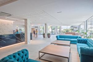 un vestíbulo con sofás azules, mesas y ventanas en Hotel Best Sol D´Or, en Salou