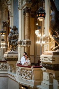 a bride and groom posing in a room with statues at QC room San Pellegrino in San Pellegrino Terme