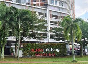 un hotel con palmeras frente a un edificio en SGA SuriaJelutong, en Shah Alam