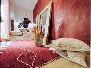 um quarto vermelho com um espelho e uma parede vermelha em DAR AURORA em Marraquexe