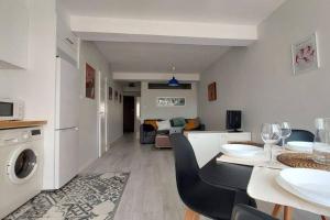 a kitchen and living room with a table and a living room at Apartamento Torre de Hércules in A Coruña