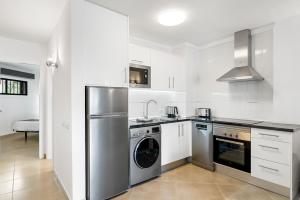 a kitchen with a stainless steel refrigerator and a dishwasher at Paloma Beach Apartments in Los Cristianos