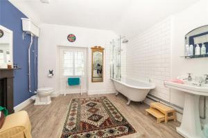 uma casa de banho com uma banheira, um WC e um lavatório. em Awel y Mor em Beaumaris