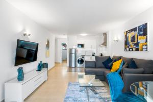 a living room with a couch and a tv at Paloma Beach Apartments in Los Cristianos