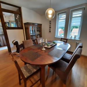 a dining room with a wooden table with a dog on it at FeWo in Ilsenburg Waldblick, schöne Aussicht in Ilsenburg
