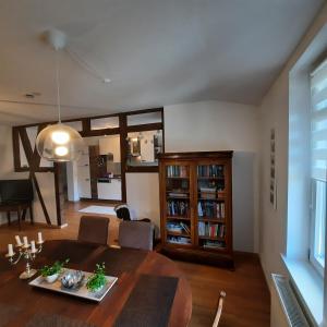 a living room with a dining room table and a kitchen at FeWo in Ilsenburg Waldblick, schöne Aussicht in Ilsenburg