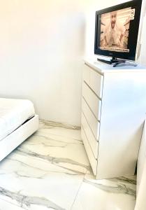- une chambre avec une télévision au-dessus d'une commode dans l'établissement Yuri’s Home, à Turin
