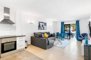a living room with a couch and a kitchen at Paloma Beach Apartments in Los Cristianos