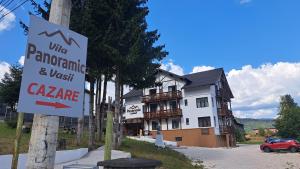 ein Schild an einem Mast vor einem Haus in der Unterkunft Vila PANORAMIC Busteni in Buşteni + 55 Fotos