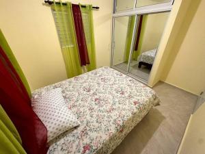 a small bedroom with a bed with a flowered blanket at house on the hill in Nagua
