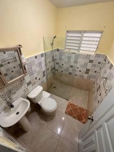 a bathroom with a toilet and a sink at house on the hill in Nagua