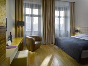 a bedroom with a bed and a desk and a chair at The ICON Hotel & Lounge in Prague