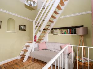 a living room with a white staircase and a chair at Hapton Folly in Waterlooville