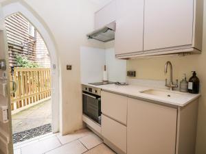 a white kitchen with a sink and a stove at Hapton Folly in Waterlooville