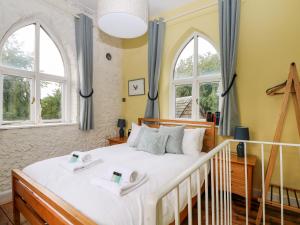 um quarto com uma cama grande e 2 janelas em Hapton Folly em Waterlooville