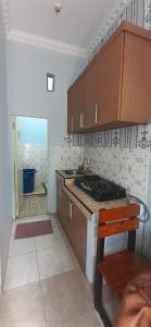 a kitchen with wooden cabinets and a counter top at D'House Homestay in Palembang