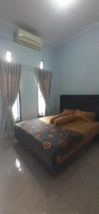 D'House Homestay في باليمبانغ: غرفة نوم مع سرير في غرفة مع نوافذ