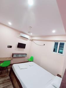 a bedroom with a bed and a desk and a table at Hotel A R S in Patna