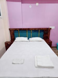 a large white bed with two towels on it at Hotel A R S in Patna