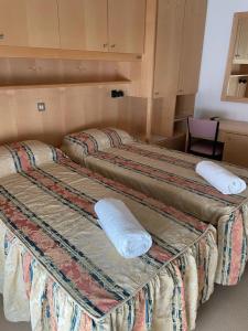 Tres camas en una habitación de hotel con toallas. en Hotel Stiefel, en Lignano Sabbiadoro