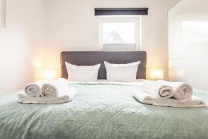 a bed with towels and pillows on it at Appartement Pier 13 in Tinnum +20 photos