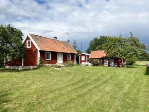 una casa roja en un campo con césped en Nice holiday home on Oland with grazing sheep in the surroundings en Borgholm