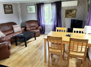 sala de estar con muebles de cuero y mesa en Nice holiday home on Oland with grazing sheep in the surroundings, en Borgholm