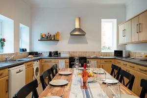 a kitchen with a long wooden table with chairs at Ventnor Views in Ventnor