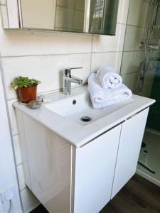 ein Waschbecken mit einem Handtuch und einem Spiegel in der Unterkunft Studio " Le Nid Perché" in Mers-les-Bains