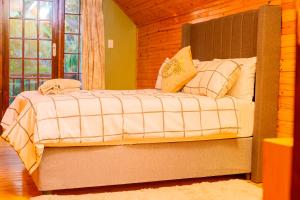 een slaapkamer met een bed met een houten muur bij Cozy Haven in East London