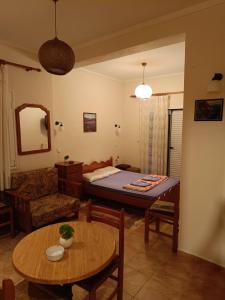 a living room with a bed and a table at Πανδοχείο Λίμνης Πλαστήρα in Kastaniá
