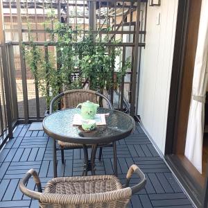 a table and chairs on a balcony with a cake on it at 雅別邸 in Kyoto