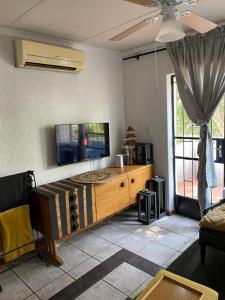 a living room with a flat screen tv on the wall at HomeSweetHome City Apartment in Nelspruit